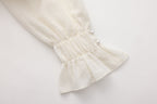 Beige V-Neck Blouse with Belt Buckle & Ruffle Trim